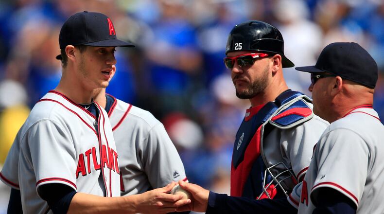 Atlanta Braves starting pitcher Matt Wisler, left, hands the ball to manager Fredi Gonzalez (33) during the eighth inning of a game against the Kansas City Royals on Sunday, May 15, 2016. (AP Photo/Orlin Wagner)