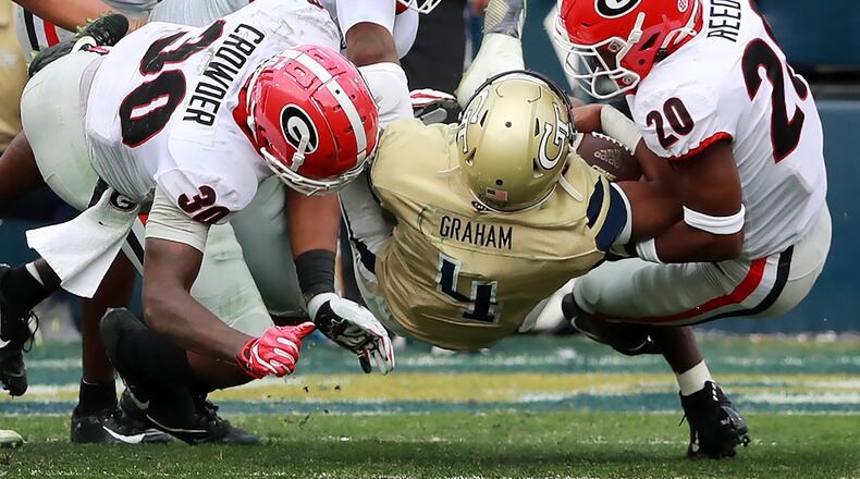 November 30, 2019 Atlanta: Georgia defenders Tae Crowder (from left), Tyler Clark, and Jr. R. Reed level Georgia Tech quarterback James Graham during the second quarter in a 52-7 Georgia victory during a NCAA college football game on Saturday, November 30, 2019, in Atlanta.  Curtis Compton/ccompton@ajc.com