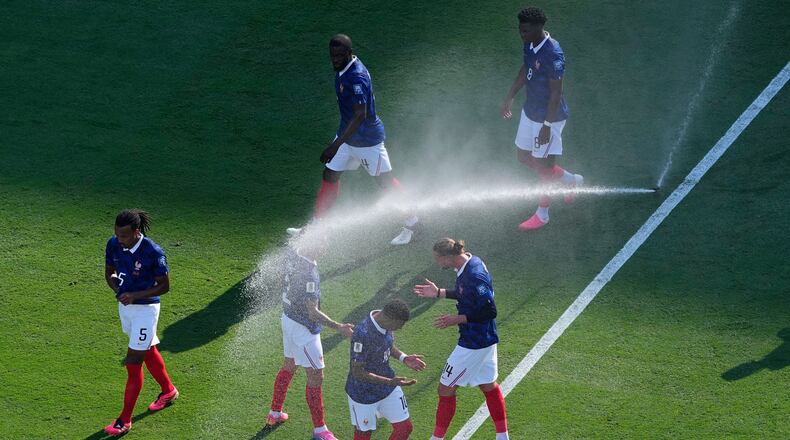 French players cool off from field sprinklers during the World Cup round of 32 soccer match against Sweden in East Rutherford, N.J., near New York, Tuesday, June 30, 2026. (AP Photo/Petr David Josek)