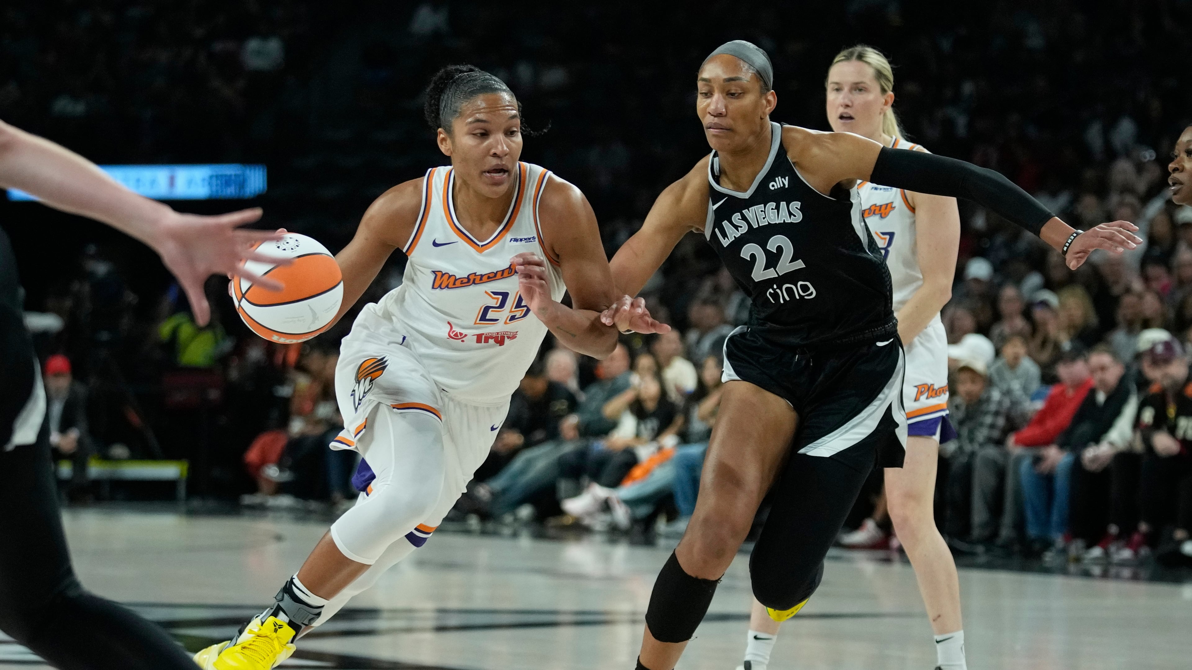 Phoenix Mercury forward Alyssa Thomas (25) drives was Las Vegas Aces center A'ja Wilson (22) defends during the first half in Game 1 of a WNBA basketball final playoff series Friday, Oct. 3, 2025, in Las Vegas. (AP Photo/John Locher)