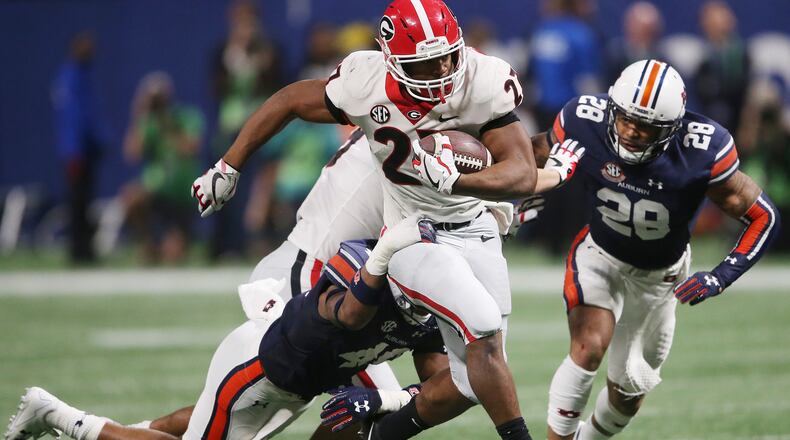 Georgia running back Nick Chubb (27) breaks the tackle of Auburn linebacker Darrell Williams (49) during the second half of the SEC Championship game, Saturday, Dec. 2, 2017, in Atlanta. (AP Photo/John Bazemore)