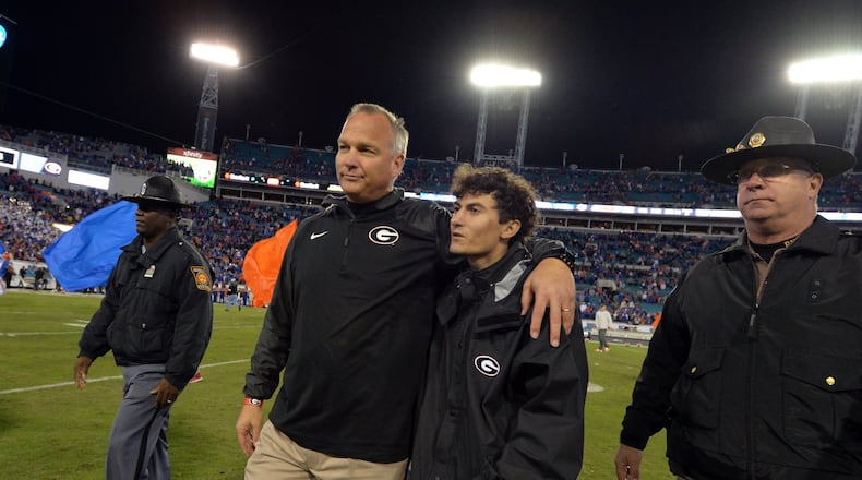 Georgia coach Mark Richt walks off the field with his son, Zach, after the Bulldog’s 38-20 loss to Florida. (Brant Sanderlin/AJC photo)