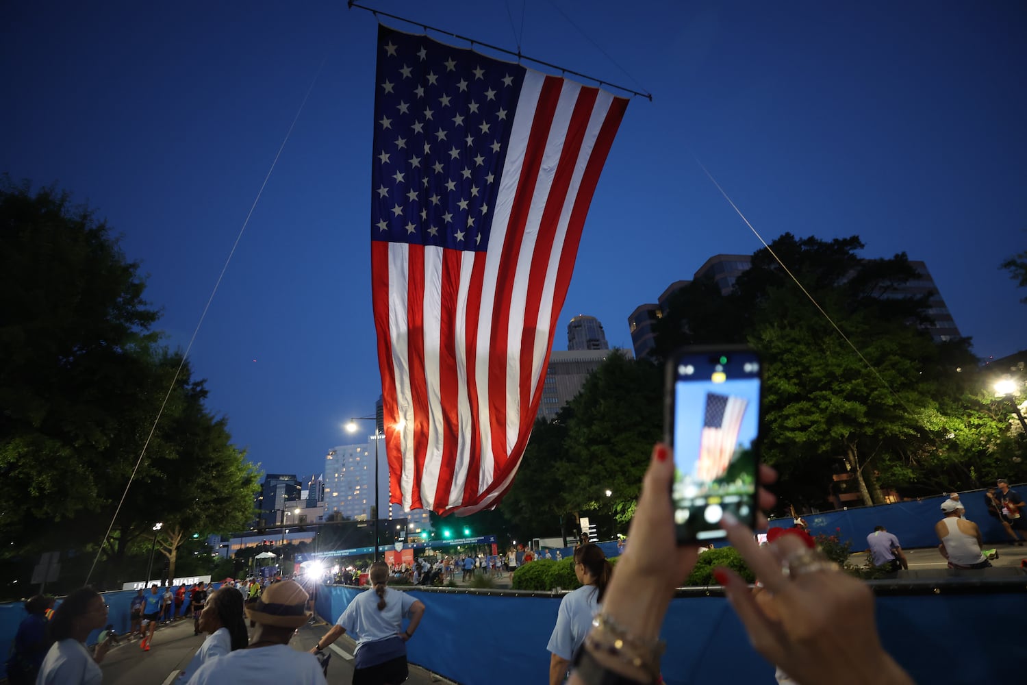 The American flag is raised at the starting line outside Lenox Square before the start of the 56th running of the Atlanta Journal-Constitution Peachtree Road Race in Atlanta on Friday, July 4, 2025. 