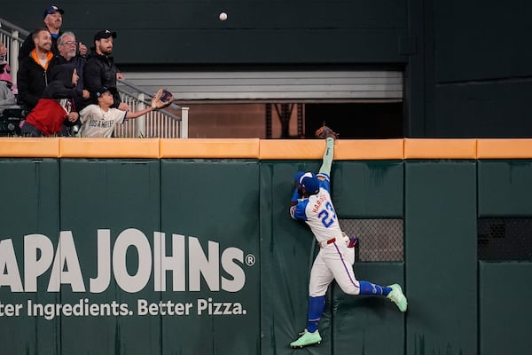 Atlanta Braves outfielder Michael Harris II (23) tries to catch the ball of the bat of Los Angeles Dodgers two-way player Shohei Ohtani (17) in the third inning of a baseball game, Saturday, May 3, 2025, in Atlanta. (AP Photo/Mike Stewart)