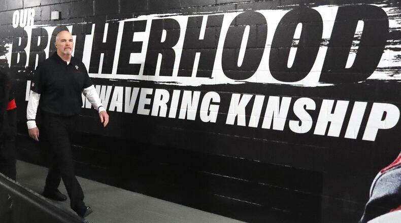 Falcons head coach Dan Quinn walks past the Brotherhood slogan in 2019.