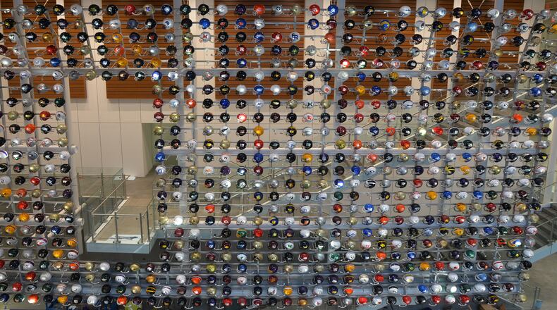 A wall of helmets greets fans at the College Football Hall of Fame. (AJC file photo by Brant Sanderlin)