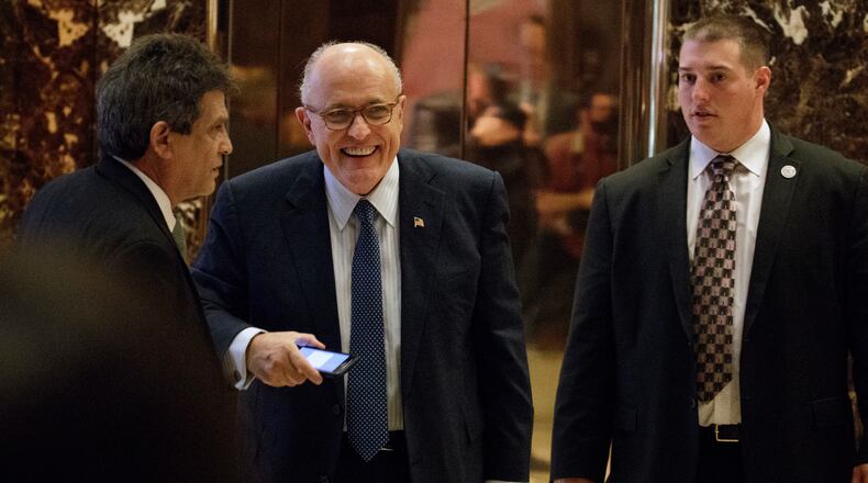 Former New York Mayor Rudy Giuliani, center, smiles as he leaves Trump Tower, Friday, Nov. 11, 2016, in New York. (AP Photo/Evan Vucci)