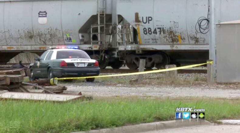 Authorities investigate the scene after a 19-year-old was struck by a train in Navasota, Texas.