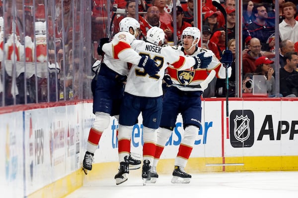 Florida Panthers' A.J. Greer (10) celebrates his goal against the Carolina Hurricanes with teammates Tomas Nosek (92) and Niko Mikkola (77) during the second period of Game 1 of the NHL hockey Stanley Cup Eastern Conference finals in Raleigh, N.C., Tuesday, May 20, 2025. (AP Photo/Karl DeBlaker)