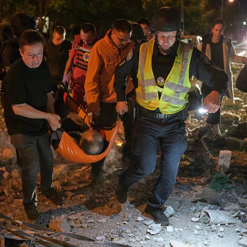 Emergency workers carry an injured person following Russian missile attacks in Kyiv, Ukraine, Monday, July 6, 2026. (AP Photo/Danylo Antoniuk)