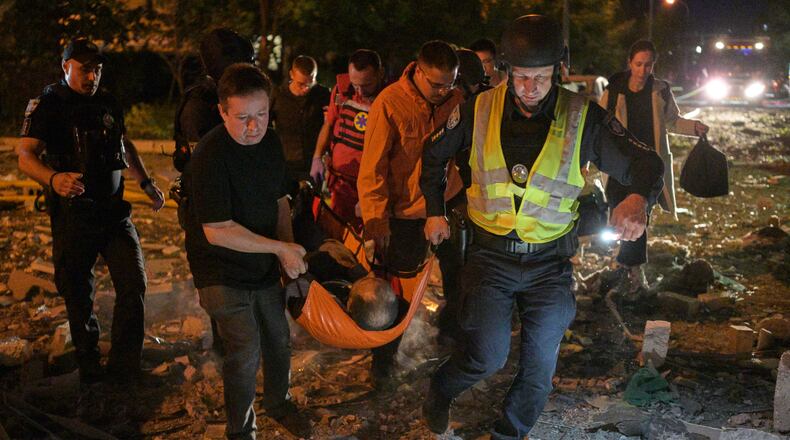 Emergency workers carry an injured person following Russian missile attacks in Kyiv, Ukraine, Monday, July 6, 2026. (AP Photo/Danylo Antoniuk)