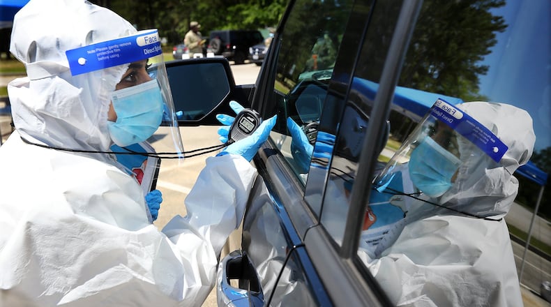 Walmart pharmacist Shama Sarangi times a motorist doing a self swab to ensure a good sample at a new mobile COVID-19 drive-through testing site to serve rural stretches of Georgia in communities without access to testing at Diamond Lakes Regional Park on Monday, April 27, 2020, in Hephzibah near Augusta. CURTIS COMPTON/ CCOMPTON@AJC.COM