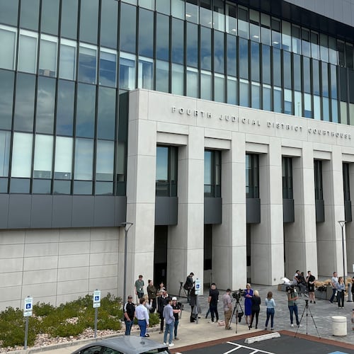 In this photo taken with a smartphone, people gather outside the Fourth Judicial District Courthouse in Provo, Utah, before a key hearing for Tyler Robinson, who is accused in the fatal shooting of Charlie Kirk, Tuesday, Sept. 1, 2026. (AP Photo/Hannah Schoenbaum)