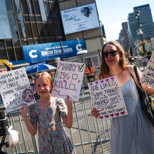 Taylor Swift fans hold signs outside of Madison Square Garden ahead of a reported wedding between singer Taylor Swift and National Football League player Travis Kelce on Friday, July 3, 2026, in New York. (AP Photo/Ryan Murphy)