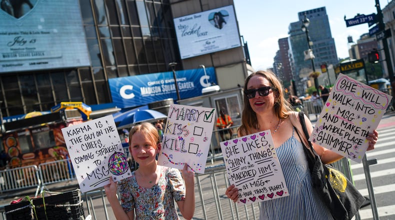 Taylor Swift fans hold signs outside of Madison Square Garden ahead of a reported wedding between singer Taylor Swift and National Football League player Travis Kelce on Friday, July 3, 2026, in New York. (AP Photo/Ryan Murphy)