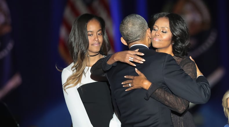 President Barack Obama and First lady Michelle embrace after the president's farewell address in Chicago on Jan. 10, 2017. Daughter Malia is standing next to them on stage.