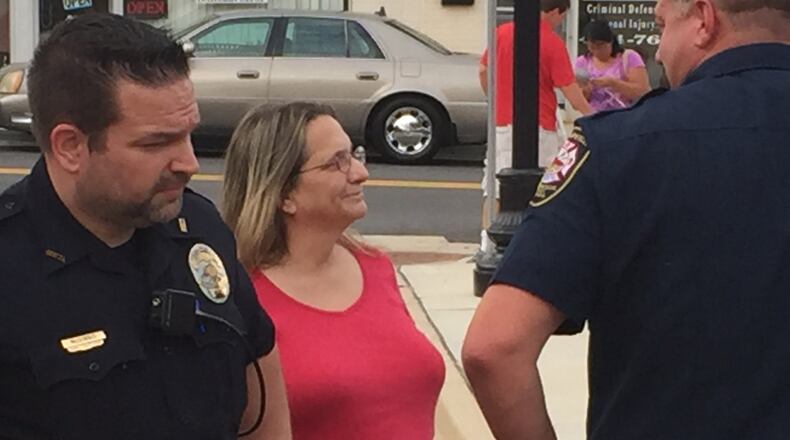 Hapeville City Councilwoman Ruth Barr talks with officers on Aug. 4, 2016, outside City Hall at the city s night out on crime event. Detective Justin McGinnis, left, signed a July 6 arrest warrant for Barr that officers later failed to execute. The department s handling of the warrant is now under review.