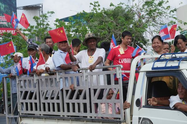 Cambodian villagers stand on a back of a truck as they arrive to welcome Chinese President Xi Jingping's arrival in Phnom Penh, Cambodia, Thursday, April 17, 2025. (AP Photo/Heng Sinith)