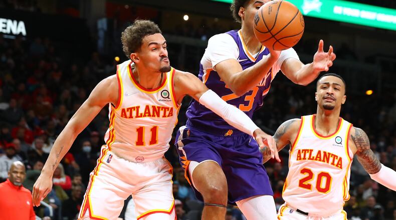 020322 Atlanta: Atlanta Hawks guard Trae Young knocks the ball away from Phoenix Suns forward Cam Johnson with John Collins looking on during the first half of a NBA basketball game on Thursday, Feb. 3, 2022, in Atlanta.  “Curtis Compton / Curtis.Compton@ajc.com”`