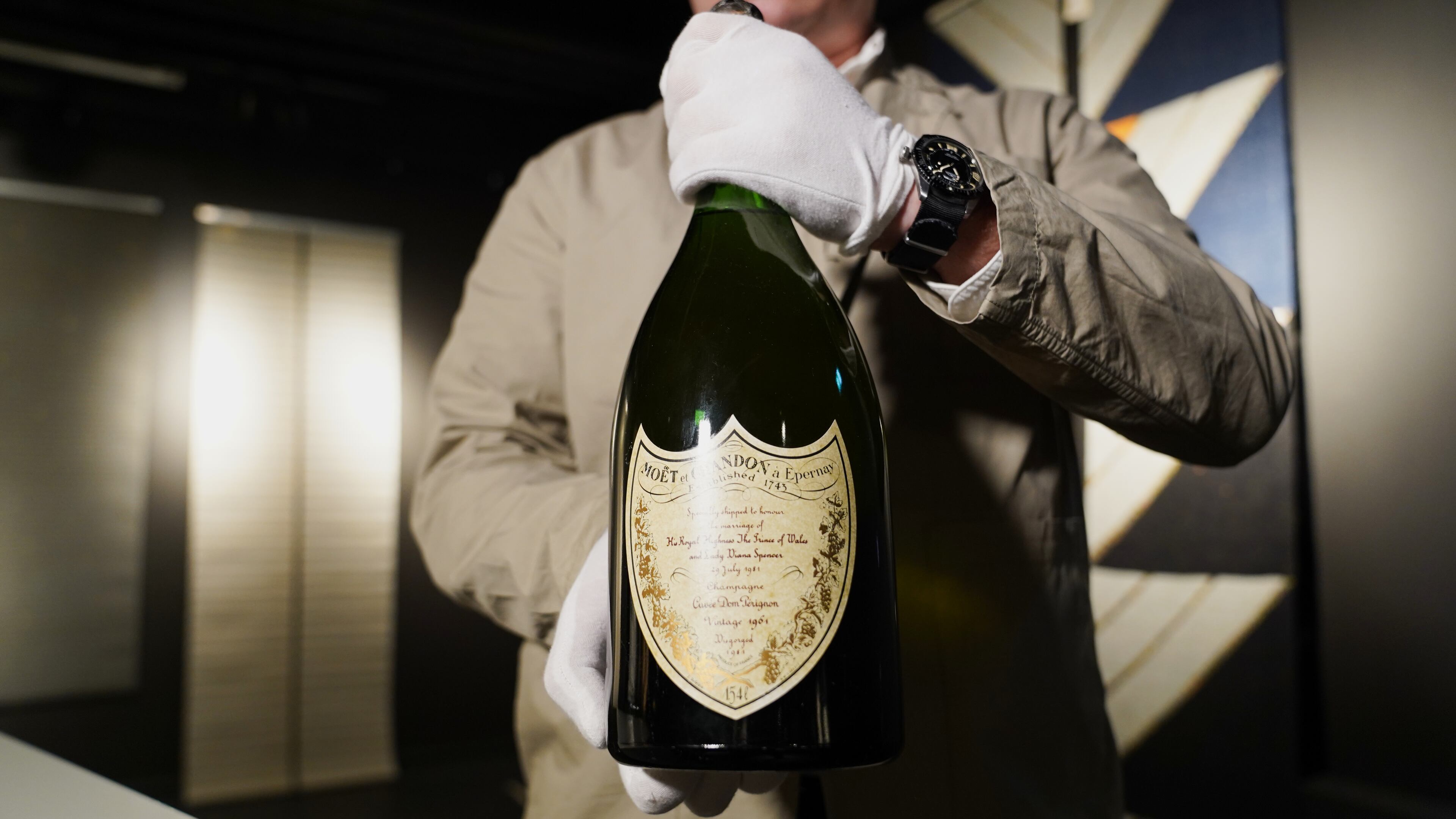 Thomas Rosendahl, head of wine department of Bruun Rasmussen auction house, holds a bottle of Dom Perignon Vintage 1961 champagne, specially produced for wedding of The Prince of Wales and Lady Diana in 1981, in Lyngby, Denmark, Wednesday, Dec. 3, 2025. (AP Photo/James Brooks)