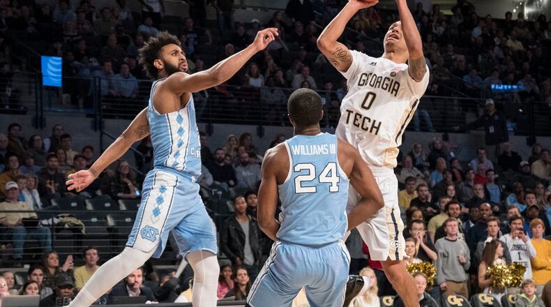 Georgia Tech guard Justin Moore (0) shoots against the defense of North Carolina guard Kenny Williams (24) and guard Joel Berry, during the second half of an NCAA college basketball game, Saturday, Dec 31, 2016, in Atlanta. Georgia Tech won 75-63. (AP Photo/John Amis)