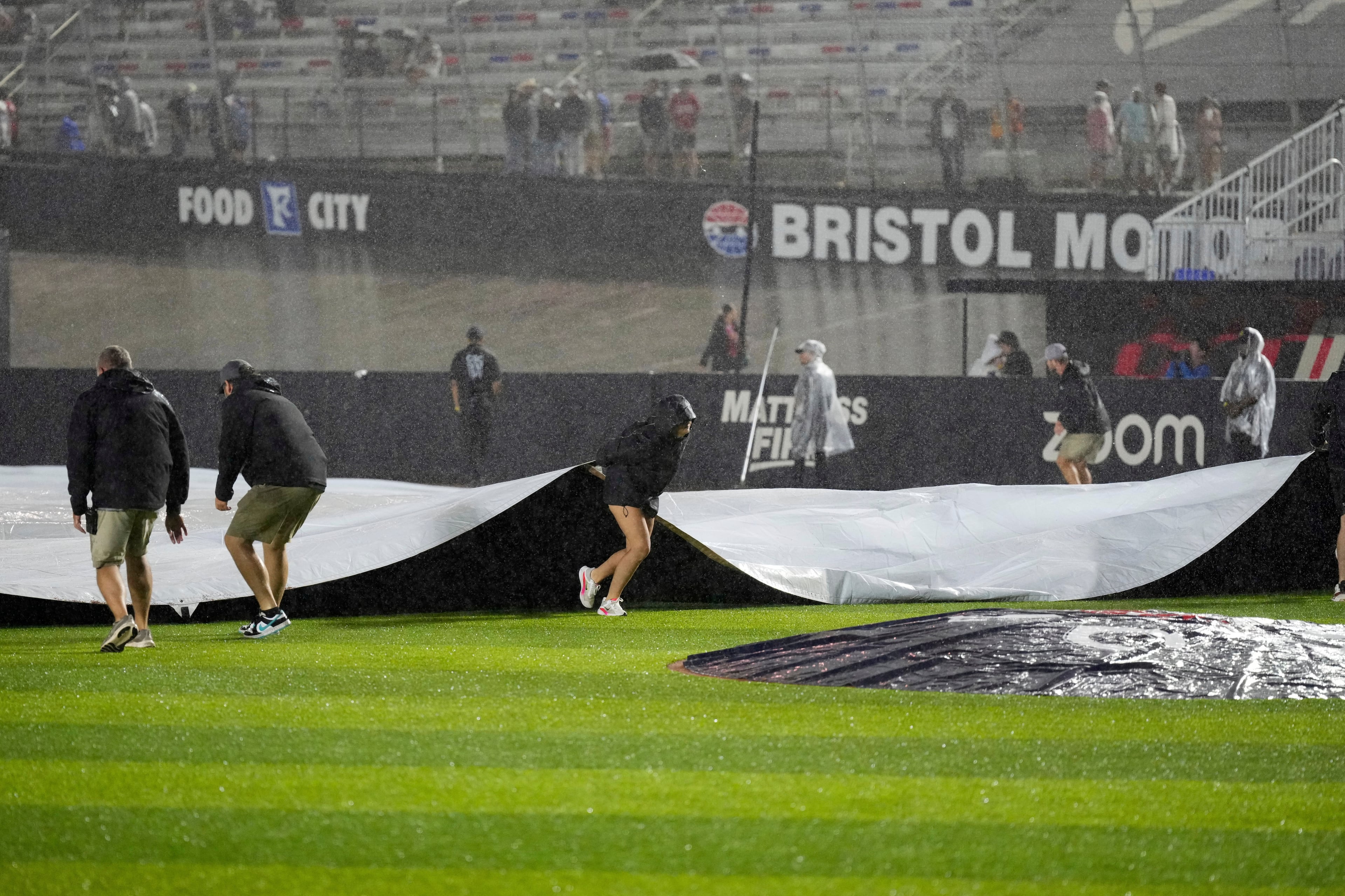 Member of the ground cover the field during a rain delay in the first inning of the MLB Speedway Classic baseball game at Bristol Motor Speedway in Bristol, Tenn., Saturday, Aug. 2, 2025. (AP Photo/George Walker IV)