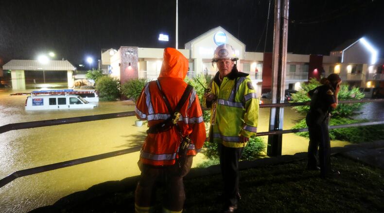 A heavy downpour caused flash flooding in Tuscaloosa, Ala., Tuesday, July 7, 2020, hitting the area of McFarland Blvd. and James I. Harrison Parkway especially hard. Tuscaloosa firefighters and police officers look for ways to get the approximately 40 stranded guests out of the Best Western on McFarland Blvd. All the hotel's first floor rooms were flooded, driving guests to the walkways on the second floor. The National Weather Service reported more than five inches of rain fell in just over an hour. (Gary Cosby Jr./The Tuscaloosa News via AP)