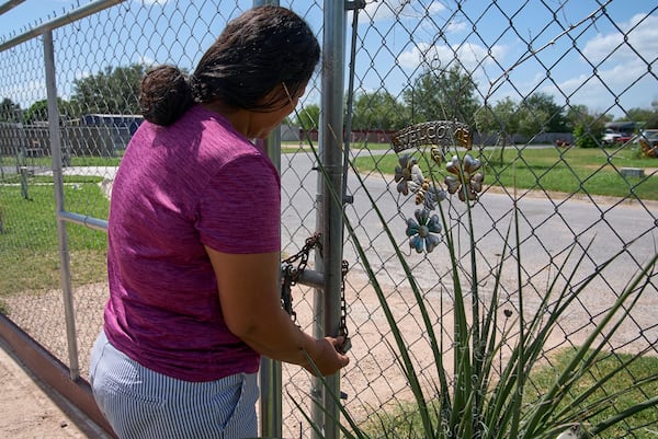 Terrified of being taken away from her children by ICE agents or police, Maria has begun locking her fence with a chain and padlock, Wednesday, June 18, 2025, at her home in Hidalgo County, Texas. (AP Photo/Jacquelyn Martin)