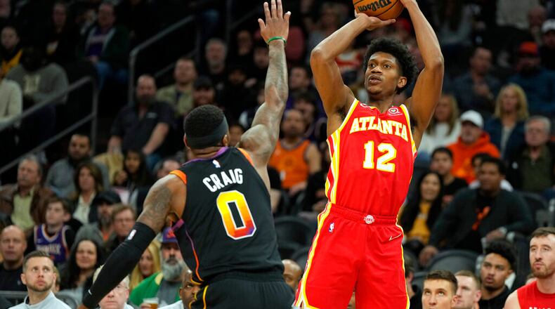 Hawks forward De'Andre Hunter shoots over Suns forward Torrey Craig during the first half Wednesday night in Phoenix. Though they still rank toward the bottom of the NBA in attempts per game (29.4), the Hawks are second in the league in 3-point efficiency (39.1) over the past 15 games. (AP Photo/Rick Scuteri)