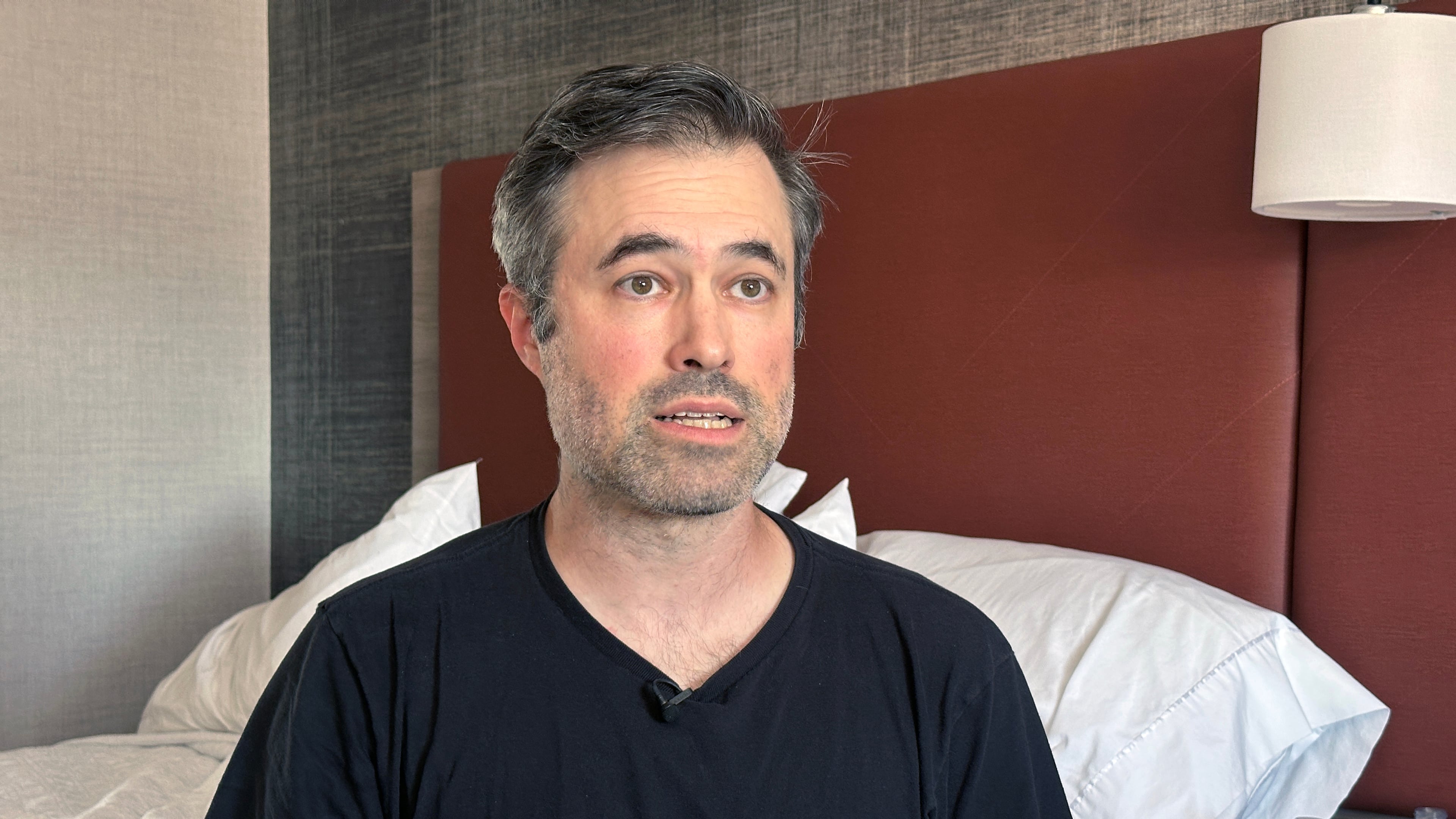 Mark Bray, a Rutgers assistant professor of history, waits in a hotel room in Newark, N.J., before a planned flight to Spain on Thursday, Oct. 9, 2025. (AP Photo/Ted Shaffrey)