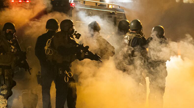 Police fire tear gas toward protesters during recent street disturbances in Ferguson, Mo.