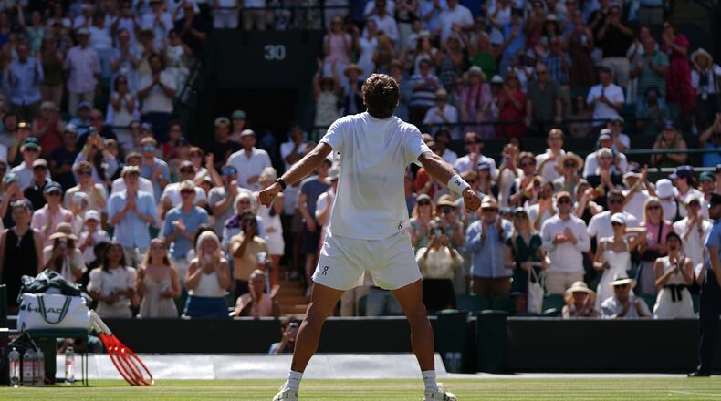 Flavio Cobolli of Italy celebrates winning against Alex de Minaur of Australia in their fourth round men's singles match at the Wimbledon Tennis Championships in London, Monday, July 6, 2026. (AP Photo/Maja Smiejkowska)