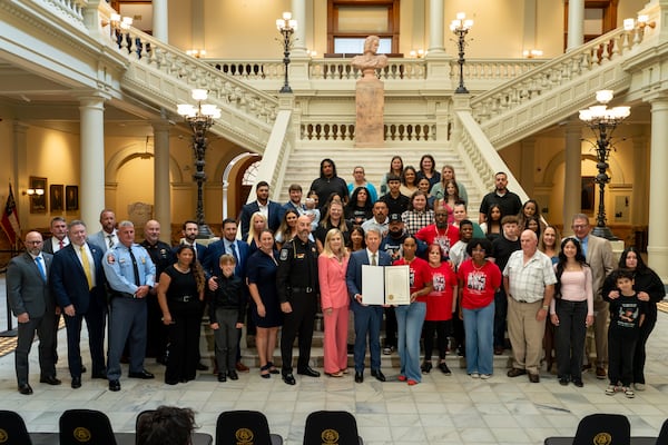 Gov. Brian Kemp, Barrow County officials and victims' family members at Thursday's ceremony. (Ben Hendren/AJC)