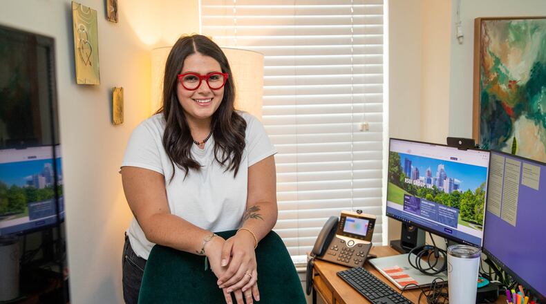 After moving to Atlanta's Old Fourth Ward in November 2020 with her husband, Hannah Evon is now fully employed after a 10-month-long search for her perfect job.  Her new employer sent IT professionals to her living room to connect her secure technology, multiple screens and install a hardwired phone with a web cam and build her Ikea desk.  (Jenni Girtman for The Atlanta Journal-Constitution)