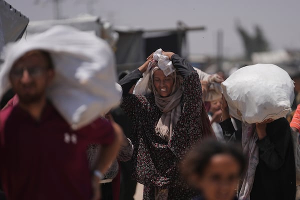 Palestinians carry bags containing food and humanitarian aid packages delivered by the Gaza Humanitarian Foundation, a U.S.-backed organization, in Rafah, southern Gaza Strip, Monday, June 16, 2025. (AP Photo/Abdel Kareem Hana)