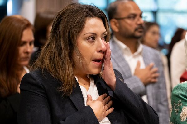 Cintia Harris, from Argentina, wipes away a tear during the Pledge of Allegiance during a ceremony where she became a naturalized citizen at The Carter Center in Atlanta on Sunday, Oct. 1, 2023. The ceremony was held at the center in honor of President Jimmy Carter’s 99th birthday.   (Ben Gray / Ben@BenGray.com)