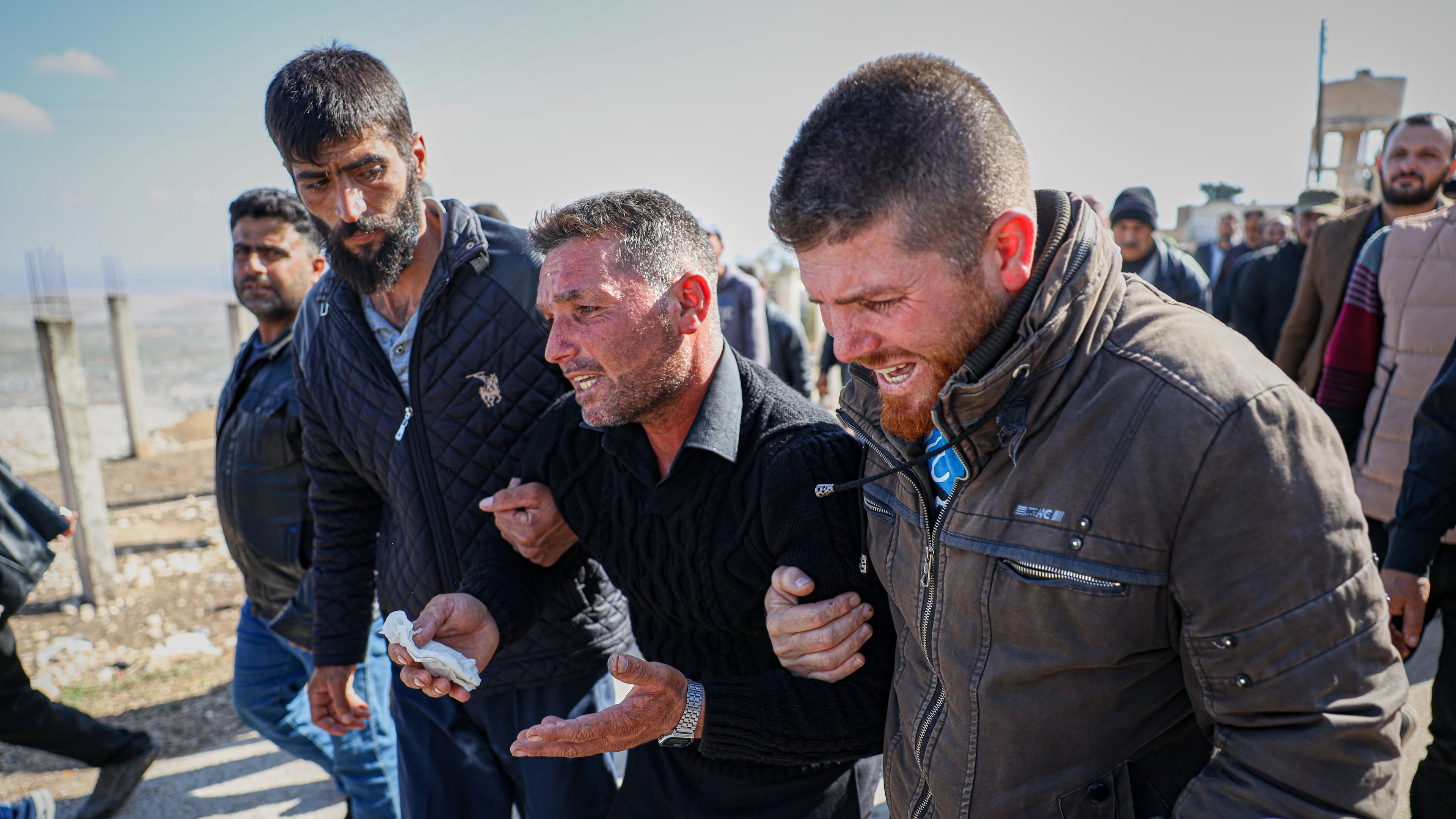 Men weep as they follow the funeral procession of three people killed when gunmen on motorcycles fired on a van near the Druze village of Kafr Maris in Syria's Idlib province, Wednesday, Oct. 22, 2025. (AP Photo/Omar Albam)