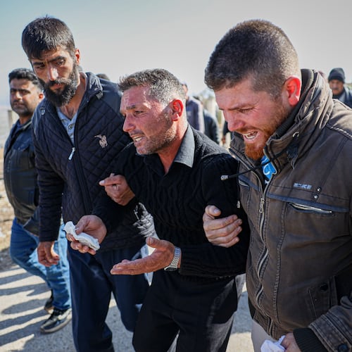 Men weep as they follow the funeral procession of three people killed when gunmen on motorcycles fired on a van near the Druze village of Kafr Maris in Syria's Idlib province, Wednesday, Oct. 22, 2025. (AP Photo/Omar Albam)