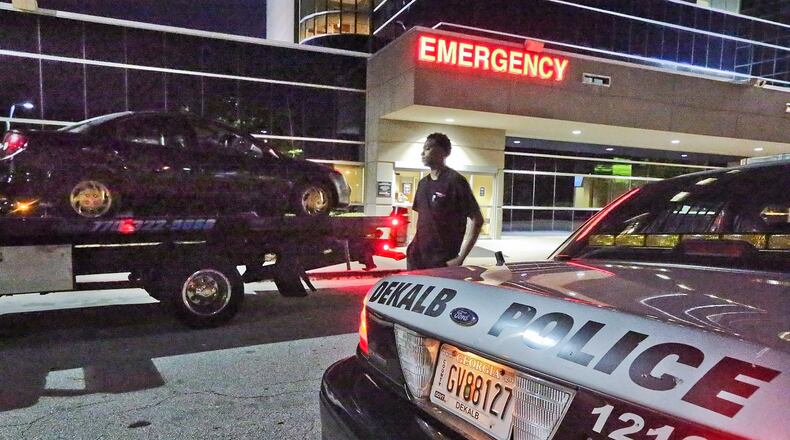 A car is towed from DeKalb Medical Hillendale after three shooting victims arrived at the hospital early Friday. JOHN SPINK / JSPINK@AJC.COM