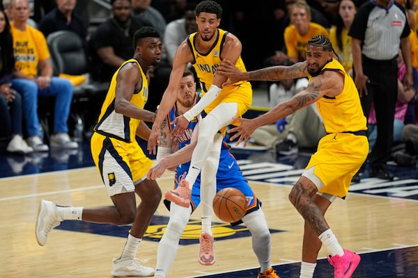 Oklahoma City Thunder center Isaiah Hartenstein passes around Indiana Pacers guard Tyrese Haliburton, right, during the second half of Game 3 of the NBA Finals basketball series, Wednesday, June 11, 2025, in Indianapolis. (AP Photo/Abbie Parr)