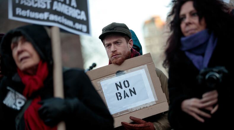FILE PHOTO: Demonstrators attend a small protest of President Donald Trump's proposed travel ban and suspension of the country's refugee program, March 16, 2017 in New York City. On Wednesday night, a federal judge in Hawaii issued a temporary restraining order on President Trump's second version of the executive order, which restricts entry to the U.S. for people from six Muslim-majority countries. (Photo by Drew Angerer/Getty Images)