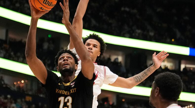 FILE - Vanderbilt forward Jalen Washington (13) shoots the ball past Arkansas forward Malique Ewin, right, during the first half of an NCAA college basketball game in the final of the Southeastern Conference tournament March 15, 2026, in Nashville, Tenn. (AP Photo/George Walker IV, File)