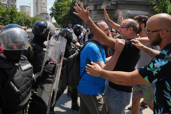 People react as Serbian gendarmerie officers remove a street blockade that was set up as part of a protest over a spate of arrests of anti-government protesters after a massive rally demanding an early parliamentary election in Belgrade, Serbia, Monday, June 30, 2025. (AP Photo/Darko Vojinovic)