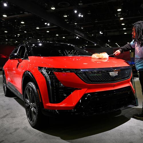 A worker dusts on a 2026 Cadillac Optiq Premium Sport vehicle at the Detroit Auto Show, Wednesday, Jan. 14, 2026, in Detroit. (AP Photo/Jose Juarez)