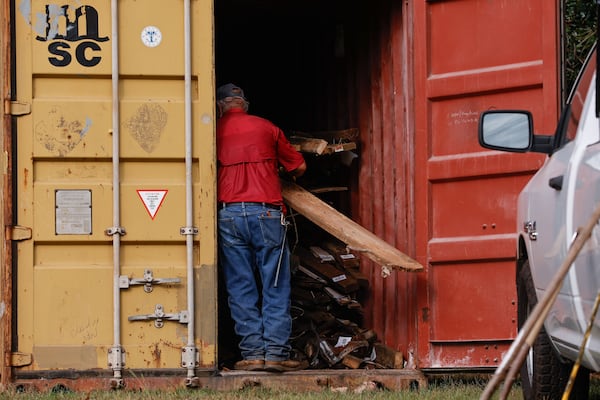 A construction worker stores wood panels from Doc’s Café in a shipping container. (Natrice Miller/ AJC)