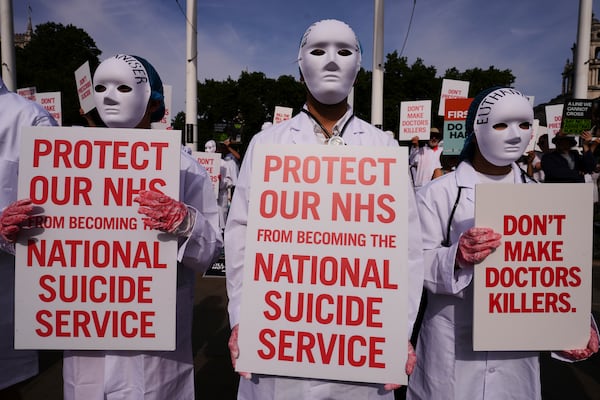 Demonstrators against assisted dying hold banners outside Parliament in London, Friday, June 20, 2025, as British lawmakers are set to vote Friday on whether to back a bill to help terminally ill adults end their lives in England and Wales. (AP Photo/Kirsty Wigglesworth)