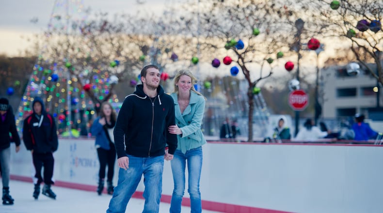 Anthony Keith (left) holds hands with Hannah Shuler as they ice skate at Atlantic Station in Atlanta during the annual Christmas tree lighting as thousands of people watch the show on Nov. 23, 2013.