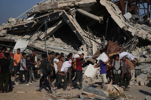 Palestinians carry humanitarian aid packages distributed by the Gaza Humanitarian Foundation operated by the U.S.-backed organization in Khan Younis, southern Gaza Strip, Thursday, June 26, 2025. (AP Photo/Abdel Kareem Hana)