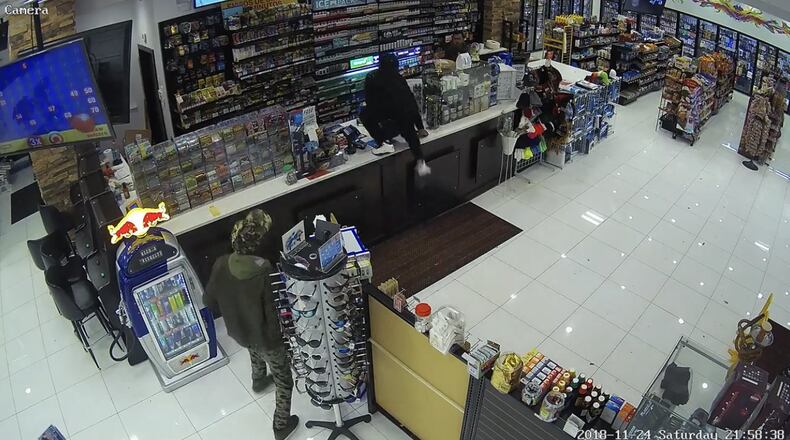 A masked robbery suspect (in all black) robbed two gas stations next to each other on Sugarloaf Highway.