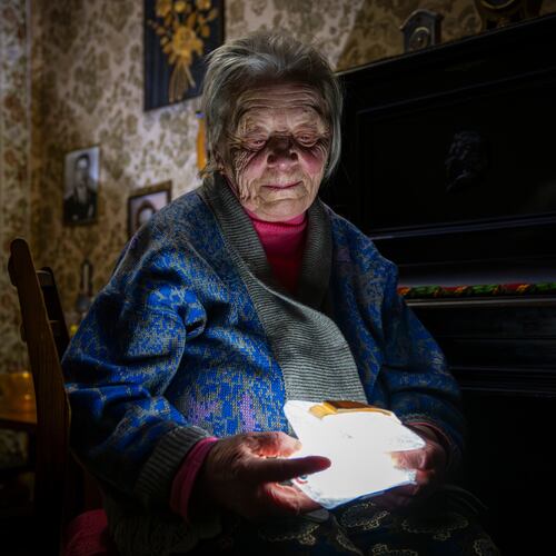 Raisa Derhachova holds a homemade flashlight during a power outage caused by regular Russian air strikes on the country's energy facilities in Kyiv, Ukraine, Tuesday, Jan. 13, 2026. (AP Photo/Dan Bashakov)